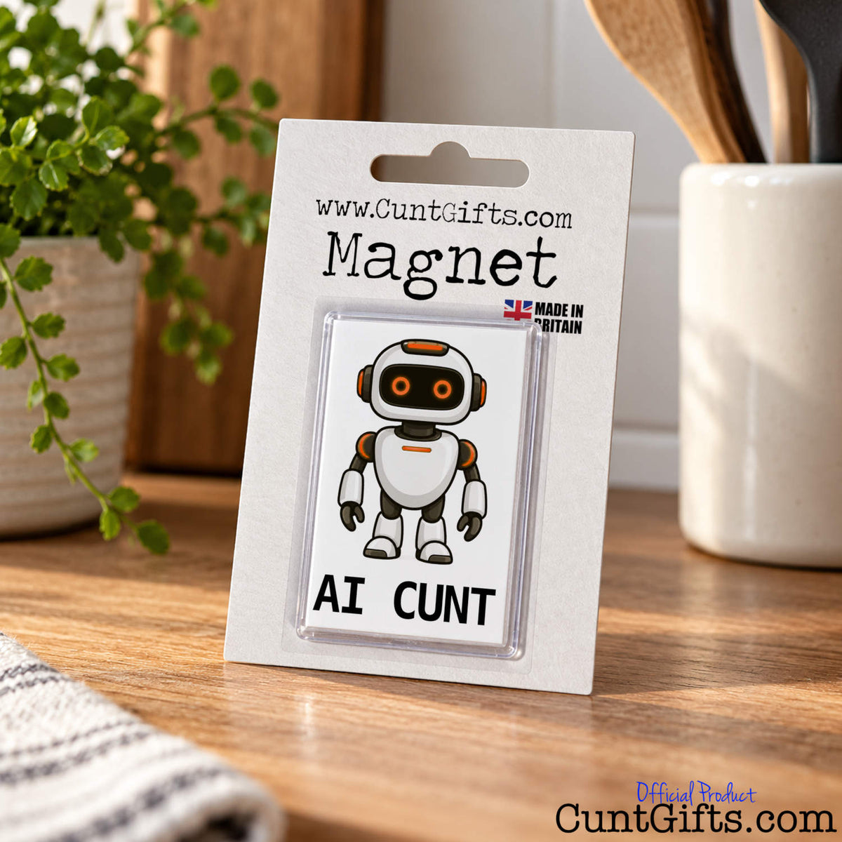 AI Cunt fridge magnet in branded packaging standing upright on a wooden kitchen worktop.