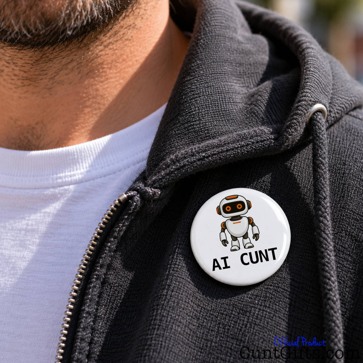 Close-up of a white AI Cunt pin badge featuring a cartoon robot attached to a black jacket.