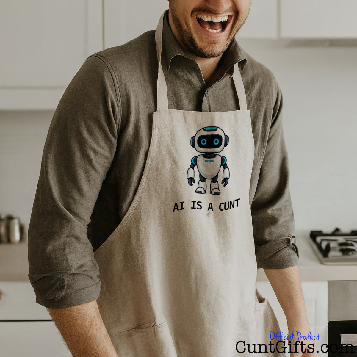Man wearing a funny AI Is a Cunt apron featuring a cheeky robot design while standing in a kitchen.