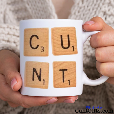 Scrabble Cunt Mug held by woman in knitted cardigan