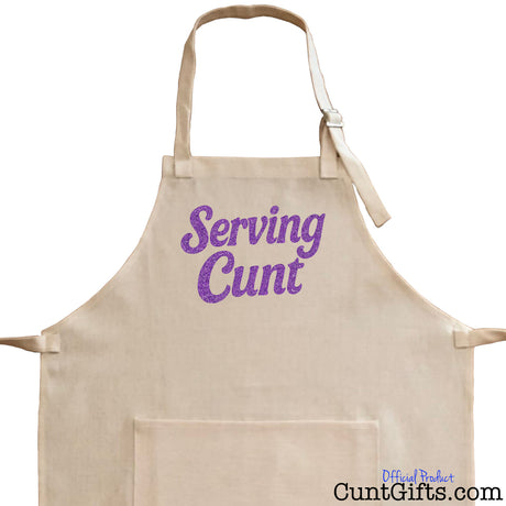 Close-up of linen cooking apron with purple text 'Serving Cunt' on a white background