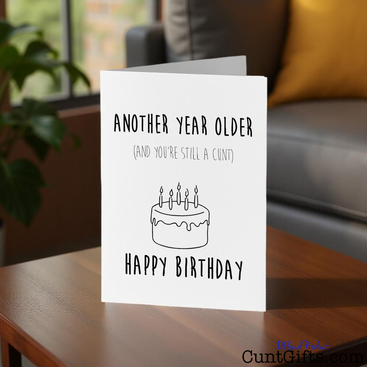 Another year older and you're still a cunt Birthday card on a table.