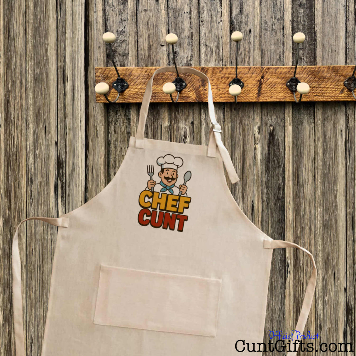 Chef Cunt apron - linen material on hook with wooden background.