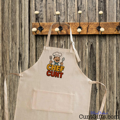 Chef Cunt apron - linen material on hook with wooden background.
