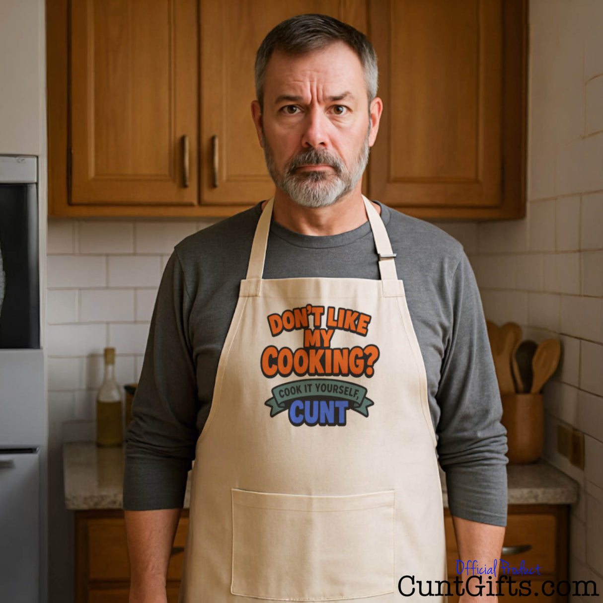 Dad in kitchen wearing cooking apron that reads "Don't like my cooking? Cook it yourself cunt"