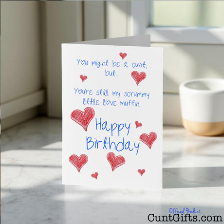 Scrummy Little Love Muffin cunt birthday card placed on a marble surface