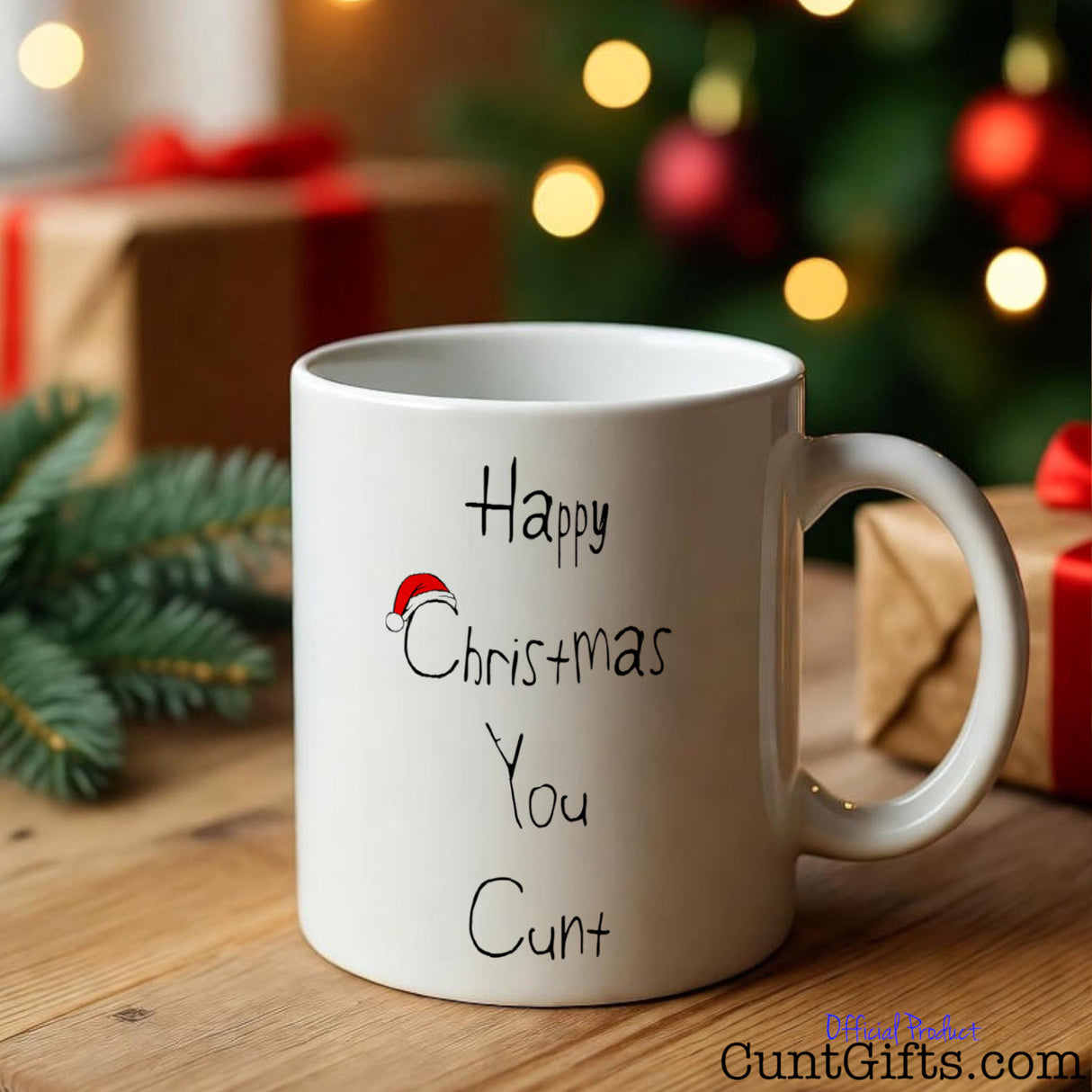 Happy Christmas You Cunt Mug by gifts and tree with fairy lights.