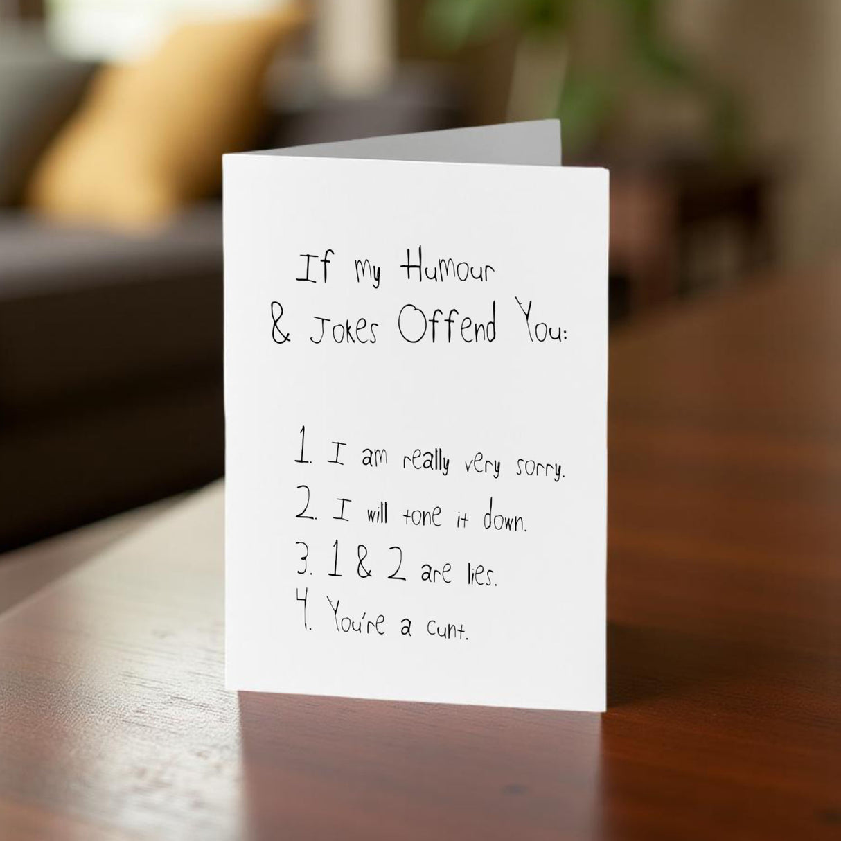 If My Humour Offends You cunt card on a table in a lounge setting