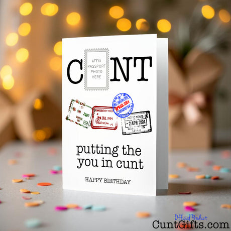 Putting the you in cunt birthday Card on a table with a bouquet of flowers on a blurred background
