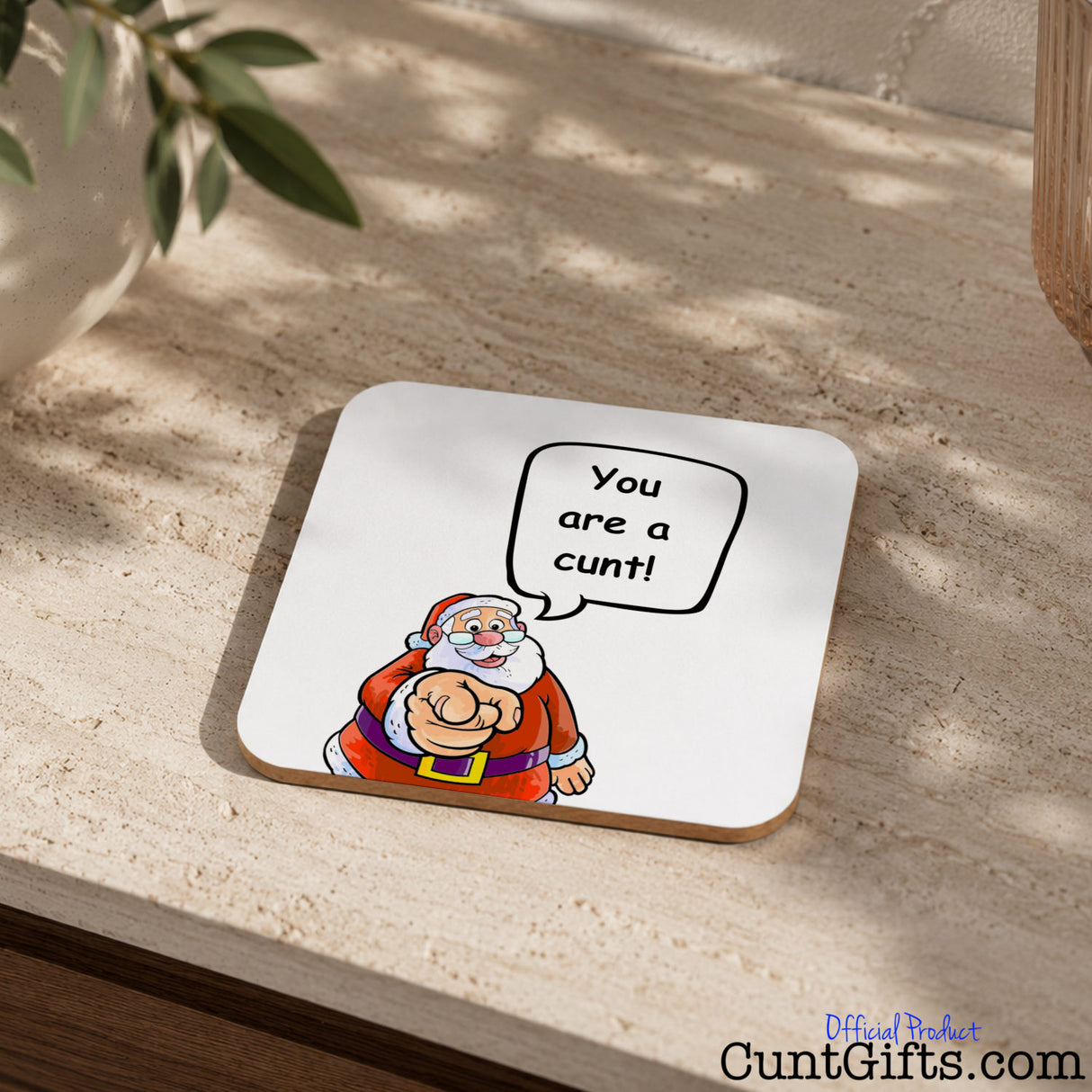 Santa says your a cunt drink coaster on stone table with plant in pot.