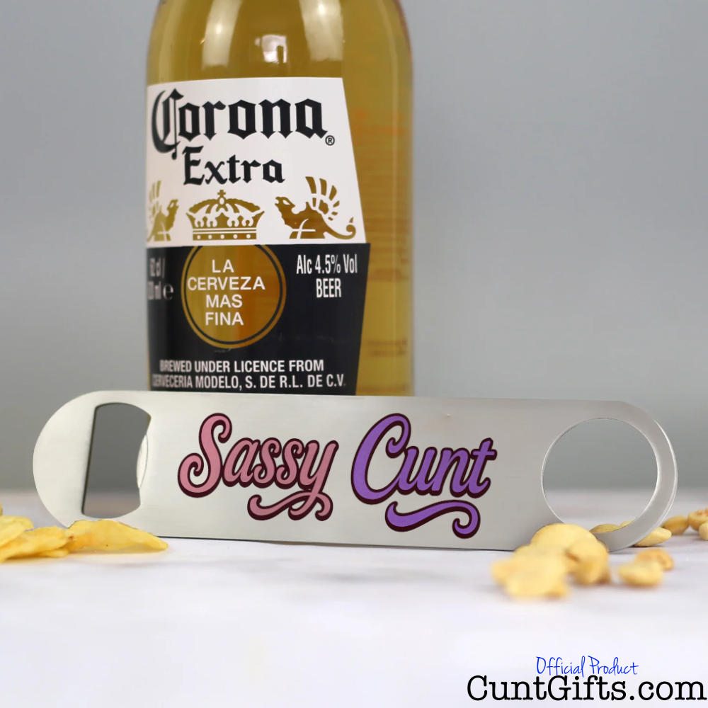 Corona Extra beer bottle with a bottle opener labelled 'Sassy Cunt' on a grey background.