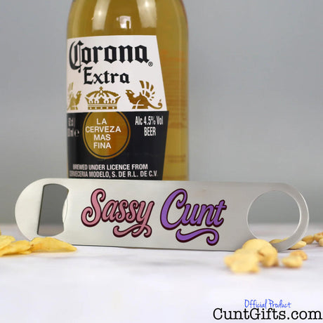 Corona Extra beer bottle with a bottle opener labelled 'Sassy Cunt' on a grey background.