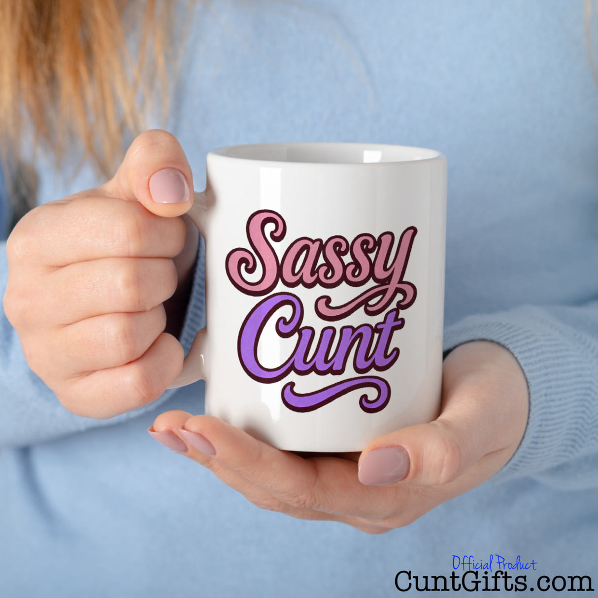 Woman in blue top holding a mug with 'Sassy Cunt' text in pink and purple on a white background