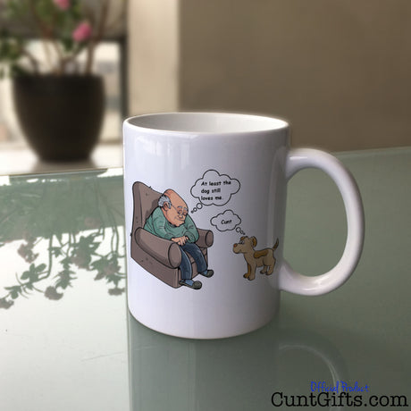 At least the dog still loves me cunt Mug on Glass Table