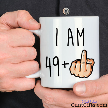 I am any age + Fuck You Mug held by man in black shirt