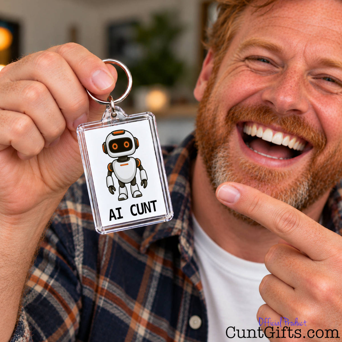 Laughing man holding up a funny AI Cunt keyring and pointing at its orange-eyed robot design.