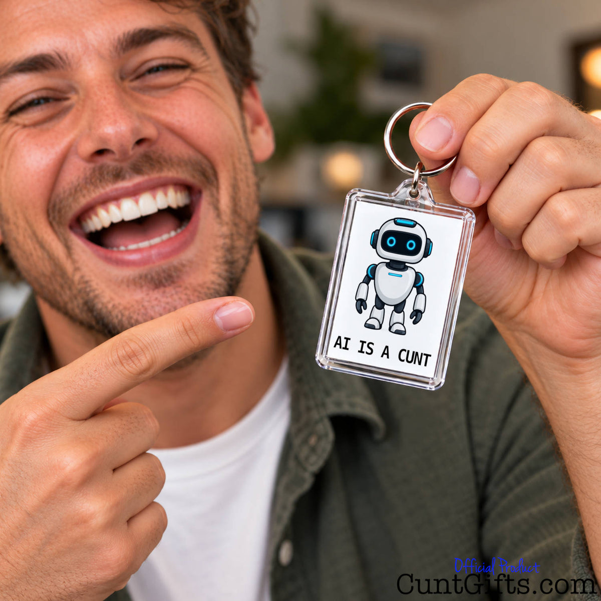 Smiling man holding up a funny AI Is a Cunt novelty keyring featuring a cartoon robot and rude slogan.