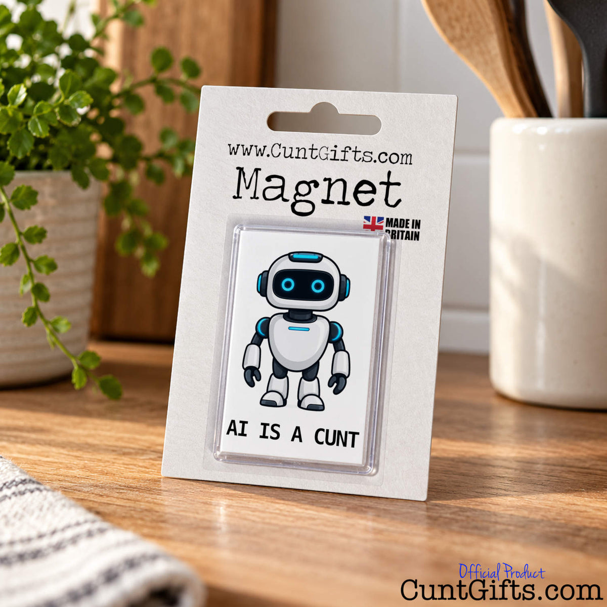 Packaged AI Is a Cunt fridge magnet featuring a funny robot design, standing upright on a wooden kitchen worktop.