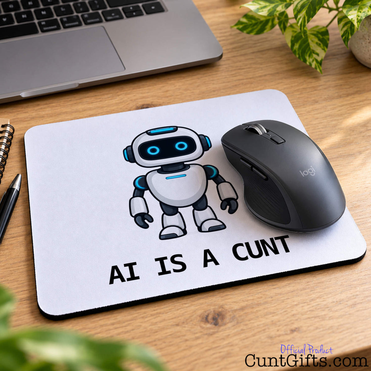 Funny AI Is a Cunt mouse mat featuring a cartoon robot with a black wireless mouse beside a laptop and green plant.