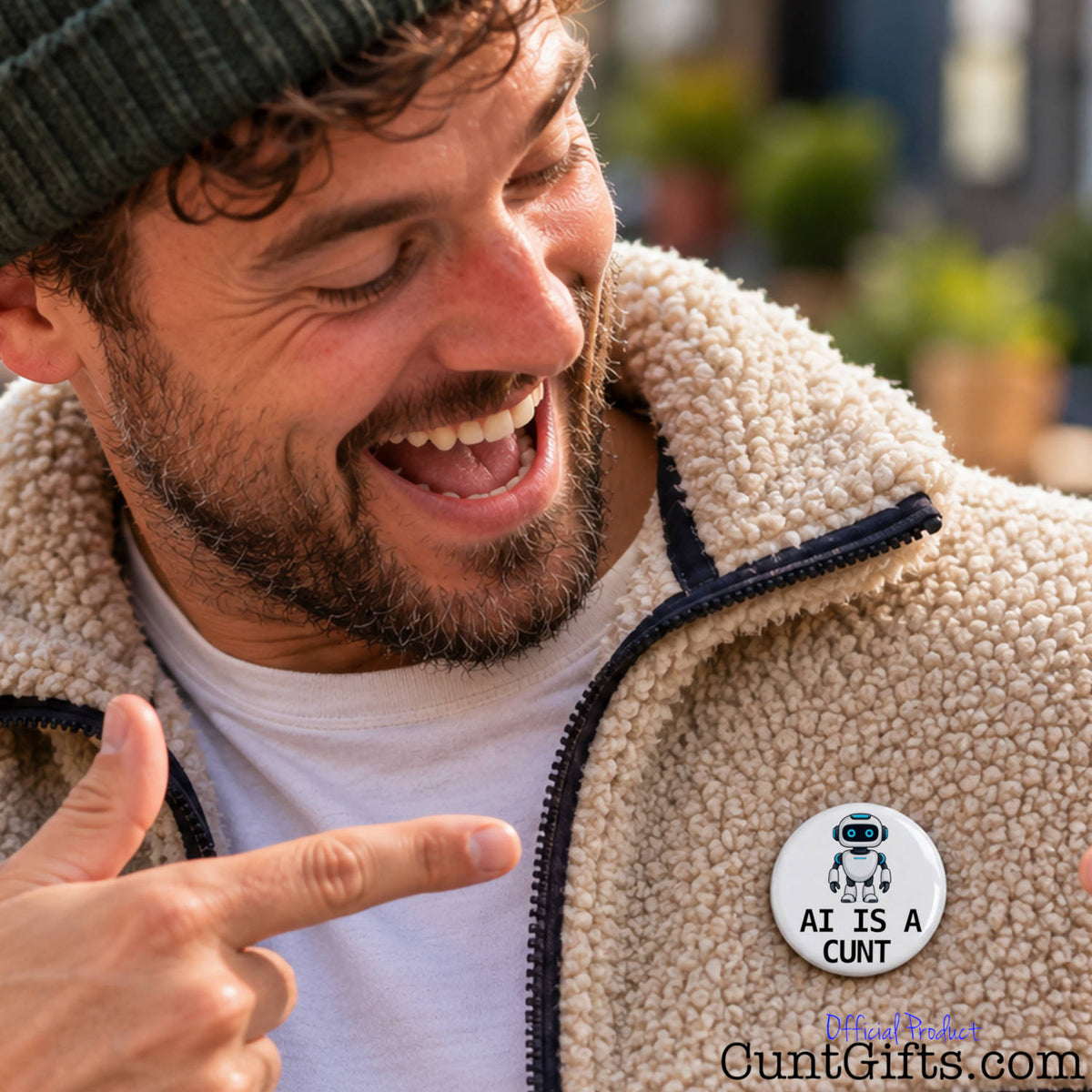 Laughing man pointing at his funny AI Is a Cunt pin badge attached to his fleece jacket.