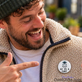 Laughing man pointing at his funny AI Is a Cunt pin badge attached to his fleece jacket.