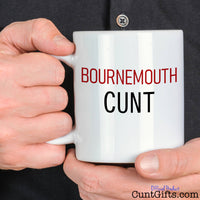 Bournemouth Cunt Mug held by man in black shirt