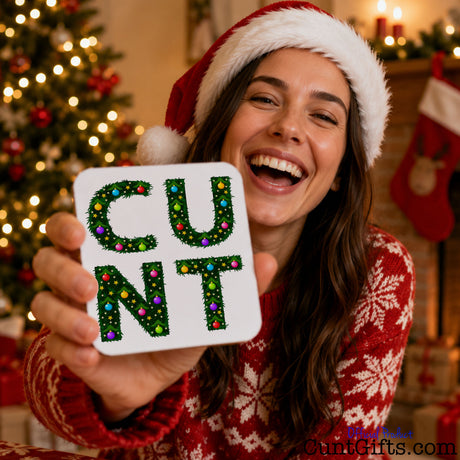 C U N T Christmas Drink Coaster held by laughing woman by Christmas tree