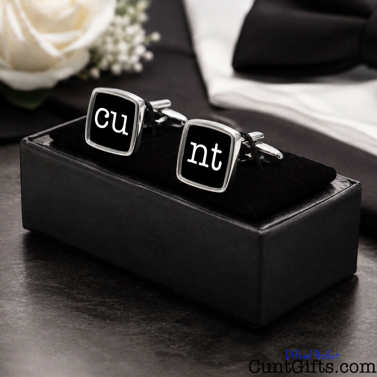 Cunt Cufflinks - CU and NT black design in presentation gift box on table with wedding background. 