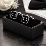 Cunt Cufflinks - CU and NT black design in presentation gift box on table with wedding background. 