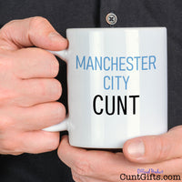Manchester City Cunt Mug held by man in black shirt
