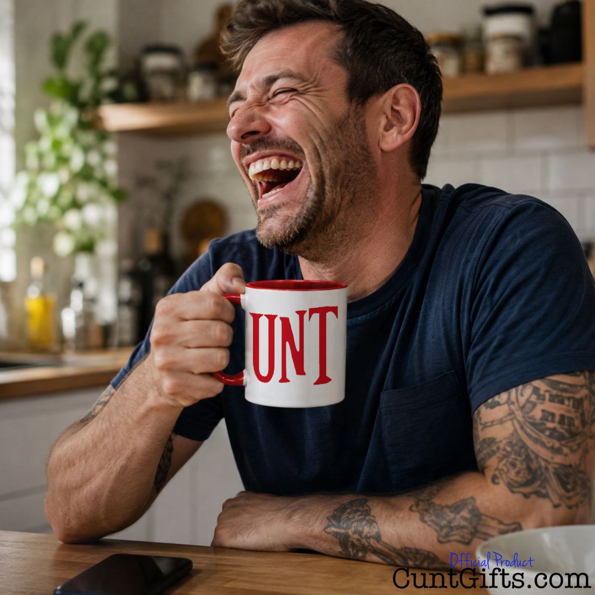 UNT Mug in red with man laughing at kitchen table with  phone.