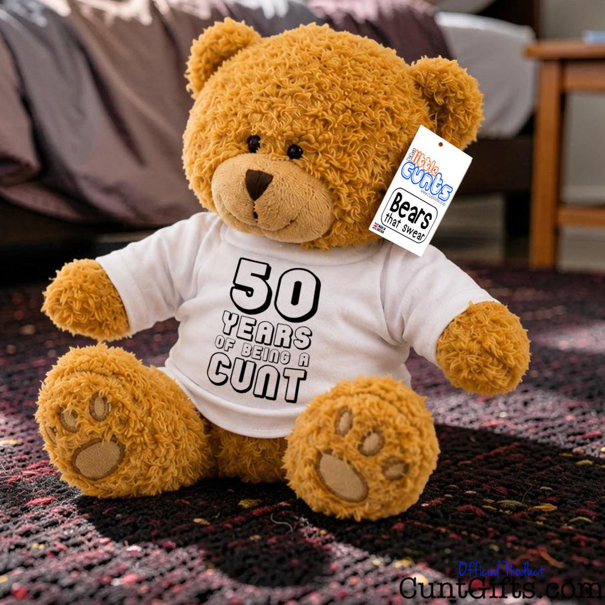 ANY Years of Being a Cunt personalised plush teddy bear with black writing sitting on purple knitted rug in bedroom.