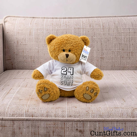 ANY Years of Being a Cunt personalised plush teddy bear with black writing sitting on natural sofa.