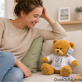 ANY Years of Being a Cunt personalised plush teddy bear with black writing sitting on sofa next to woman smiling wearing jeans with plant in background.
