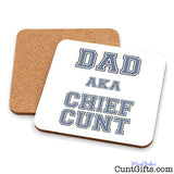 Two square cork coasters on a white background, with one coaster in front reading “DAD AKA CHIEF CUNT” in grey outlined block letters.