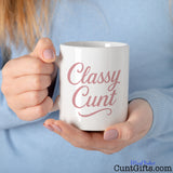 Classy Cunt mug held by woman in a blue sweater