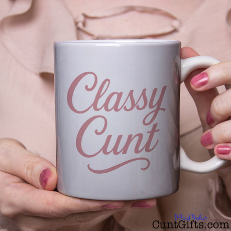 Classy Cunt mug held by woman in pink blouse
