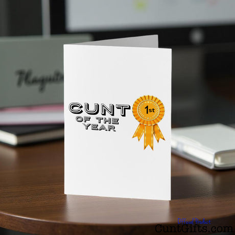 Greeting card with Cunt of the Year design on a desk