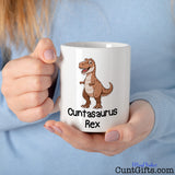 Cuntasaurus Rex Mug held by woman in blue sweater