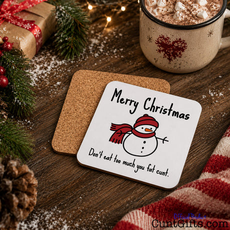 Don't Eat Too Much You Fat Cunt - Christmas drink coaster showing both sides and cork backing on festive table with gifts and hot chocolate and snow.