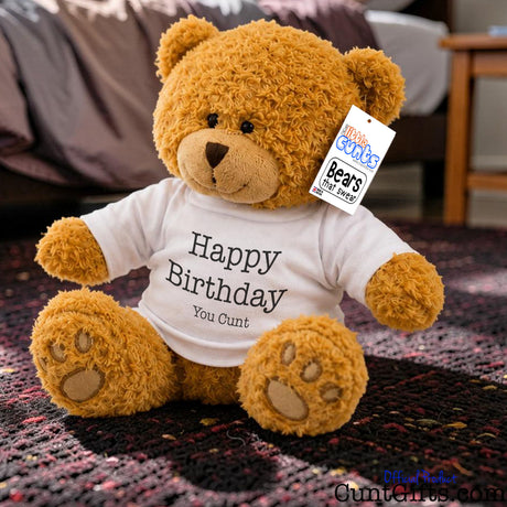 Happy Birthday You Cunt - Teddy Bear Plush sitting on purple rug on bedroom floor.