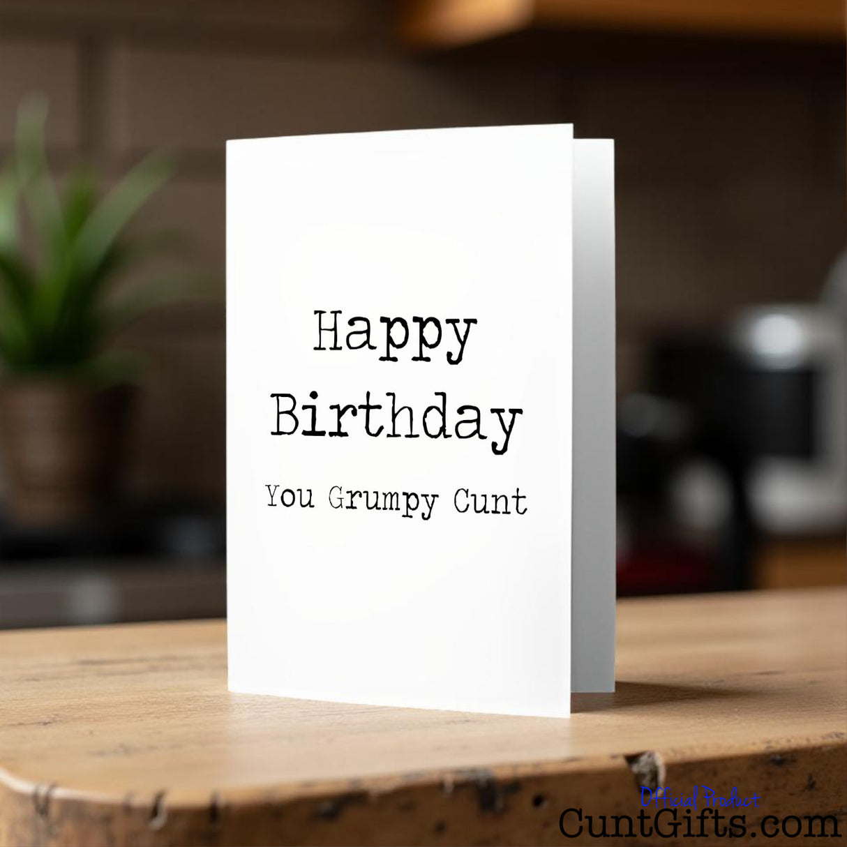 Happy Birthday You Grumpy Cunt birthday card on a wooden surface with a blurred background