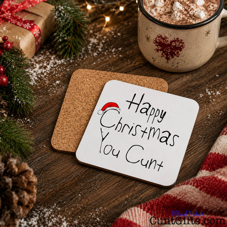 Happy Christmas You Cunt drink coaster showing both sides with cork backing in festive scene with hot chocolate and snow.