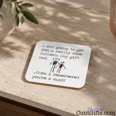 I remembered you're a cunt Dad -  Father's Day Drink Coaster on stone table next to plant in pot.