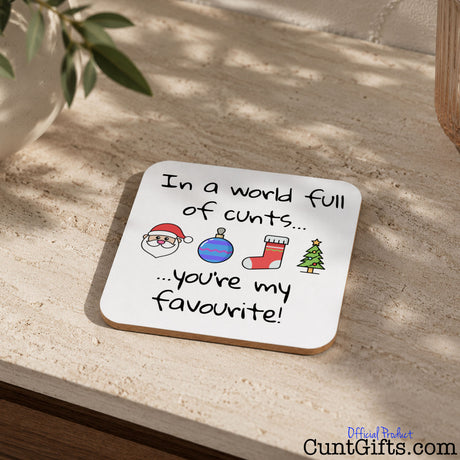 In A World Full Of Cunts You're My Favourite - Christmas Drink Coaster on table by plant and plant pot.