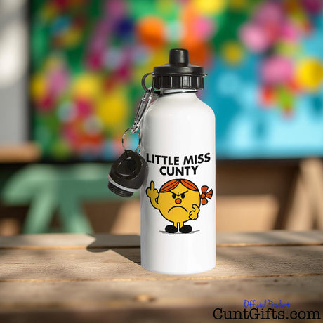 Little Miss Cunty Water Bottle on table with colourful painting in background