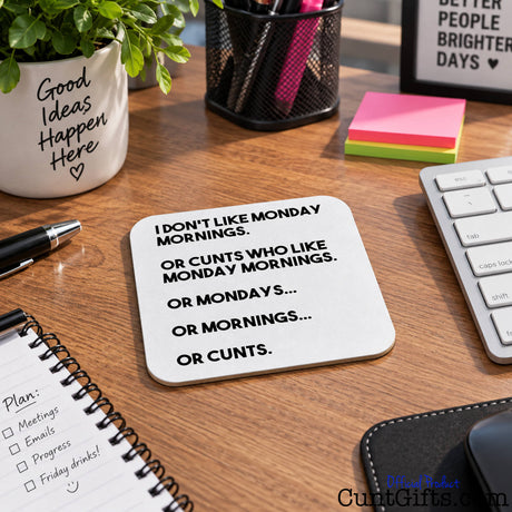 A square white coaster with rounded corners featuring black text that reads 'I DON'T LIKE MONDAY MORNINGS. OR CUNTS WHO LIKE MONDAY MORNINGS.