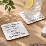 A square white Father's Day coaster on table with a glass of lemon water, with black printed text reading 'Most stepdads are cunts  ...but you're alright - Happy Father's Day'.