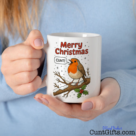 "Merry Christmas Cunt" Mug featuring a robin held by woman in blue jumper