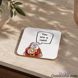 Santa says your a cunt drink coaster on stone table with plant in pot.
